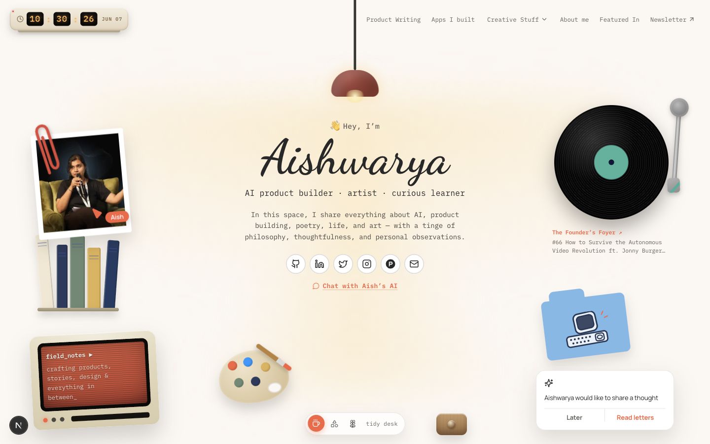 A screenshot of aishashok.com redesigned as a warm desk with clickable objects, a lamp, and mode controls.